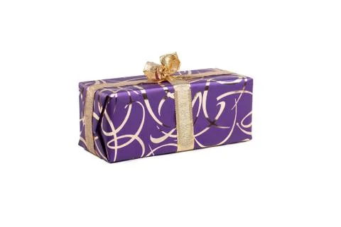 Packaged rectangular gift in purple packaging with gold bow and gold pattern on Stock Photos