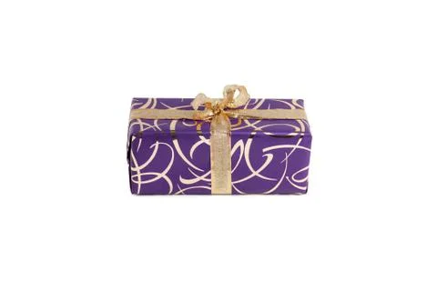Packaged rectangular gift in purple packaging with gold bow and gold pattern on Stock Photos