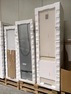 Packaged refrigerators of various sizes placed on pallets in retail warehou.. Stockfoto's