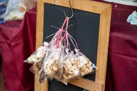Packaged street snacks hanging on chalkboard Bangkok market Stock Photos