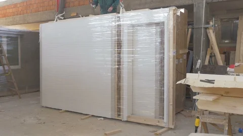Packaged wall construction in factory hall,tilt up,worker fixing wooden elements 動画素材 99259494