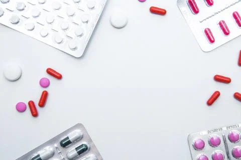 Packages and tablets are on the sides of photos with handfuls of tablets and Stock Photos
