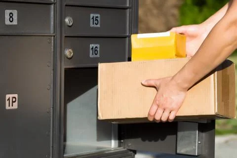 Packages being loaded into postal mailbox Stock Photos