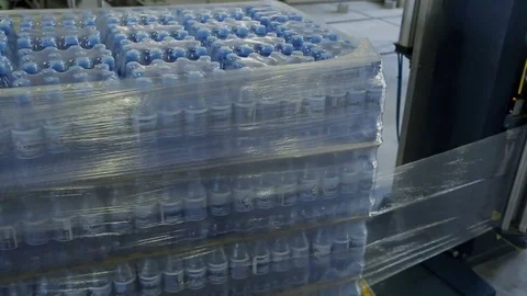 Packages with bottled water are packed in polyethylene automatically. Video stock 81072118