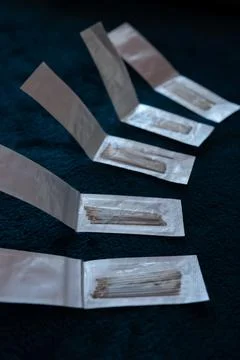 Packages with needles in plastic bags on a plain background Stock Photos