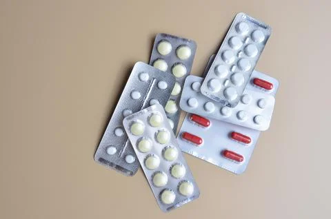 Packages of tablets on a beige background. Stock Photos