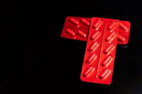 Packages of tablets in a red wrapper on a black background. Foto stock