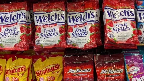 Packages of Welchs Fruit Snacks, Starburst, Hot Tamales and Skittles candies. Stock Footage 201635963