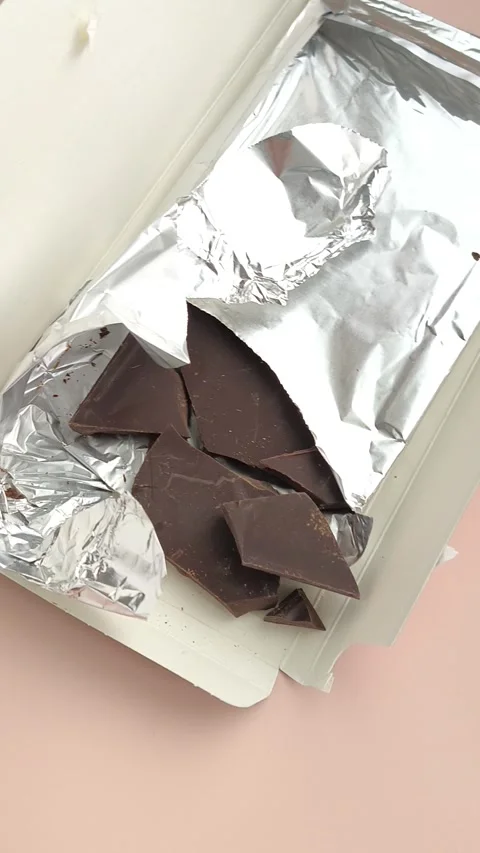 Packaging with chocolate in foil close-up on the table. Natural chocolate Stock Footage 324555058