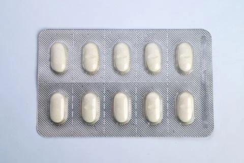 Packaging concept showcasing uniform oblong tablets in foil packs. Product prese Fotos de archivo