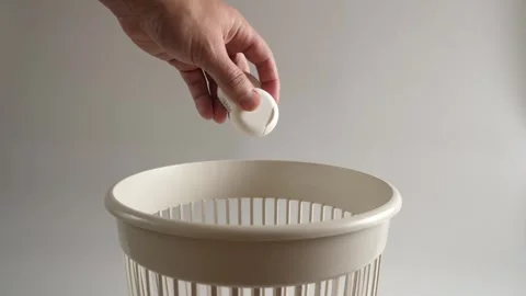 The packaging from the dental floss is thrown into the trash for disposal Stock Footage 260476090