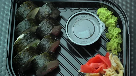 Packaging of Fresh Sushi Rolls with Wasabi and Ginger in a Special Box Stock Footage 174337771