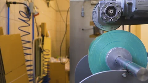 Packaging machine using plastic foil, close up tracking shot Stock Footage 129877186