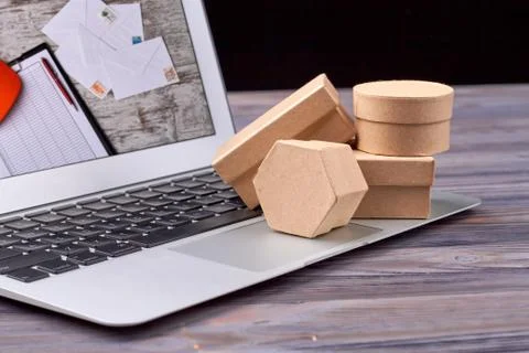 Packaging paper and shipping boxes on laptop. Stock Photos