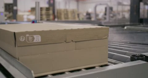 Packaging process close-up: Cardboard box moving on conveyor Stock-Footage 258260946