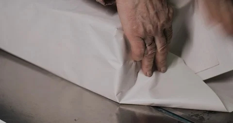 Packaging process of a sheaf of newspaper held by a woman on the old newspaper Stock Footage 103510711