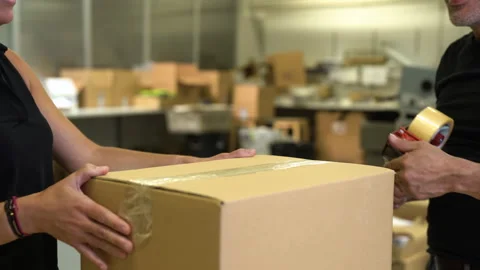 Packaging with tape couple of workers labor caucasian preparing box for 動画素材 263542297