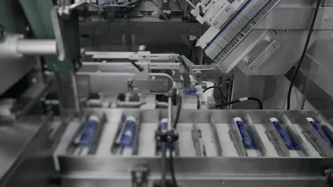 Packaging of tubes with cream in cardboard boxes at a cosmetics factory. Stock Footage 306581492