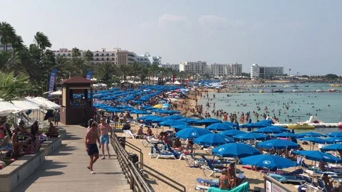 Packed beach with blue umbrellas in protaras Stock Footage 91478267