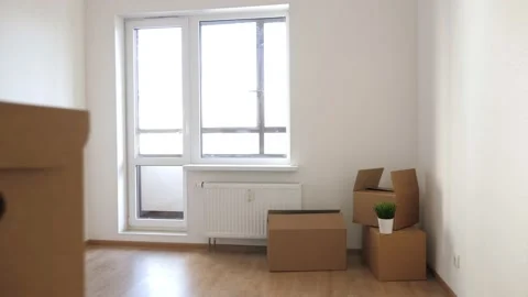 Packed household boxes for movement in empty room Stock Footage 143544082