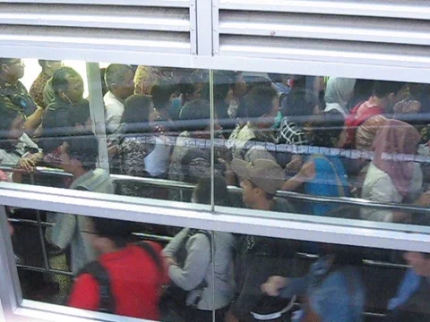 Packed people queueing at Transjakarta bus station 库存影片 76700234
