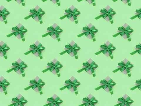 Packed present pattern in the craft paper with the ribbon on green background. Stock Photos