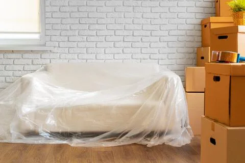 Packed sofa and stack of cardboard boxes in a room. Moving concept Stockfoto's