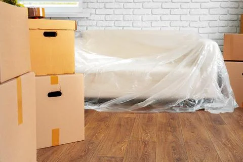 Packed sofa and stack of cardboard boxes in a room. Moving concept 写真素材