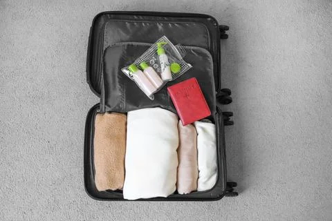 Packed suitcase. View from above. Things are folded into a roll, mini trave.. Фото
