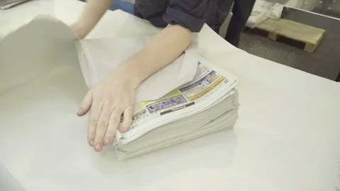 Packer packing newspapers in white wrapping paper in print house Stock Footage 71509012