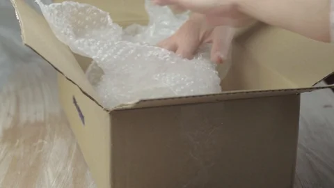 Packing a box with bubble wrap Stock Footage 112878010