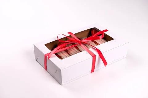Packing box with eclair with glaze and strawberries, isolated on white, close Stock Photos