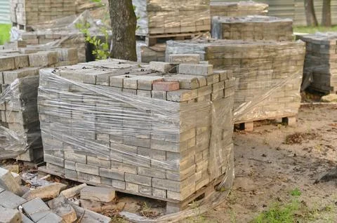 Packing bricks on pallets in a construction warehouse on the street. Repair.. Stock Photos
