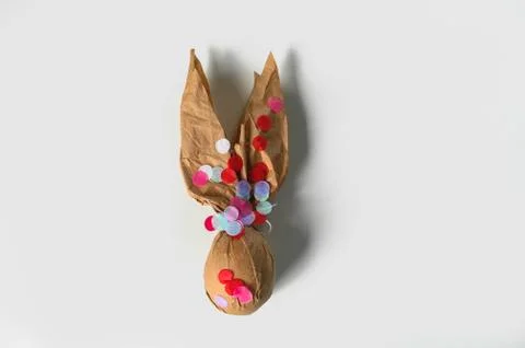 Packing an Easter egg in paper in the form of an Easter bunny. Stock Illustration