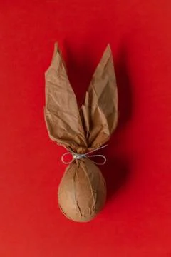 Packing an Easter egg in paper in the form of an Easter bunny. Stock Photos