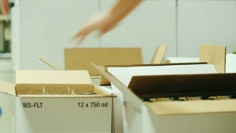 Packing of finished products in the winery. Workers put bottles in cardboard Stock Footage 82993871