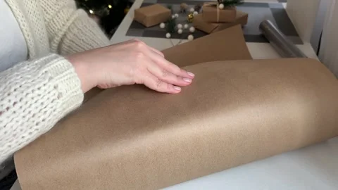 Packing a gift box in craft wrapping paper, preparing for the holiday Stock Footage 255657170
