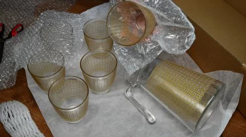 Packing up glassware into plastic bubble wrapping Foto stock