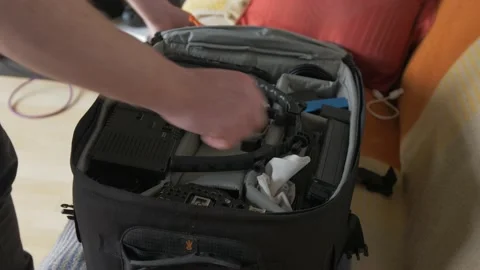 Packing heavy camera bag and zipping it up preparing for shoot. CLOSE UP Stock Footage 160521206