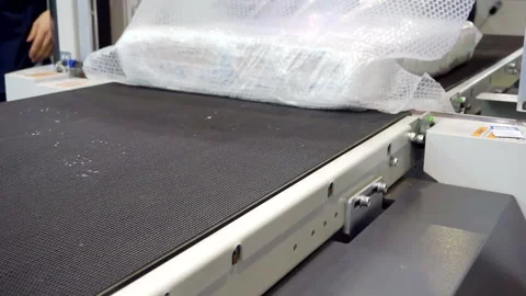 Packing machine packs the finished product in a plastic film. close-up. Stock Footage 142017547