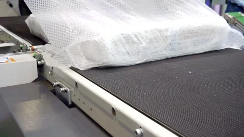 Packing machine packs the finished product in a plastic film. close-up. Stock Footage 142017556