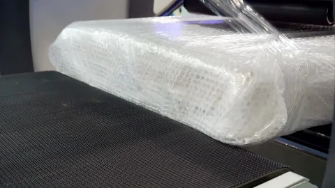 Packing machine packs the finished product in a plastic film. close-up. Stock Footage 142017648