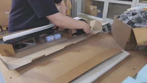 Packing plastic parts in a box. The worker puts the goods in a box for sending Stock-Footage 167019213