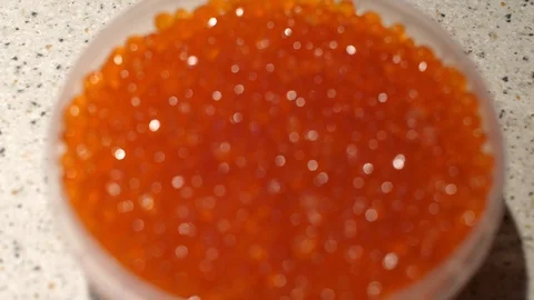 Packing red caviar shiny in the light. Plastic jar with red caviar of sea fish 動画素材 119352521