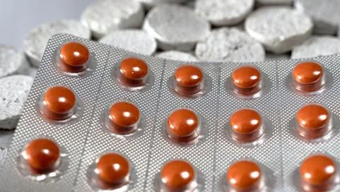 Packing with red pills on a gray structural background. Stock Photos