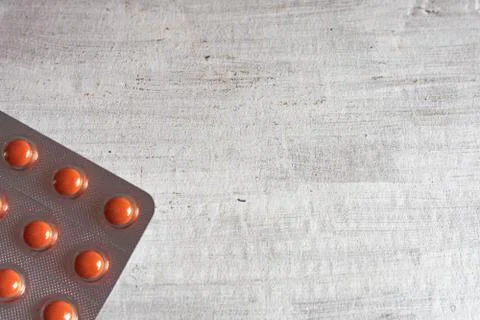 Packing with red pills on a gray structural background. Stock Photos