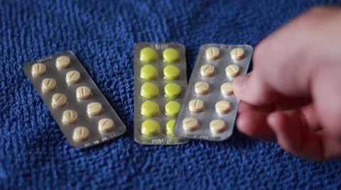 Packing tablets on blue background Stock Footage 63456581