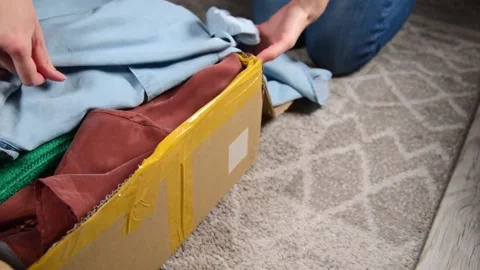 Packing used clothes in box. Stock Footage 147053762