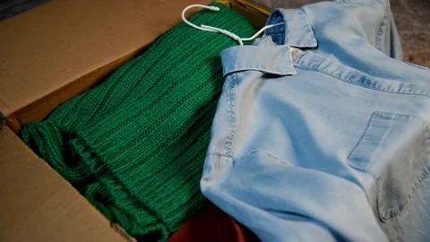 Packing used clothes in box. Video stock 147053860