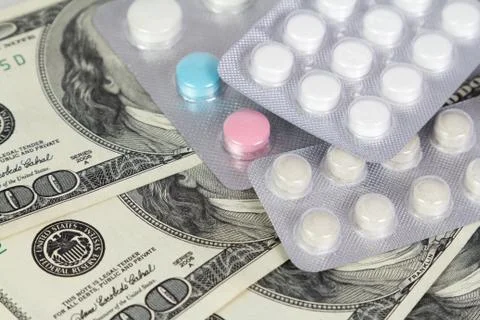 The packings of pills lying on dollars Stock Photos
